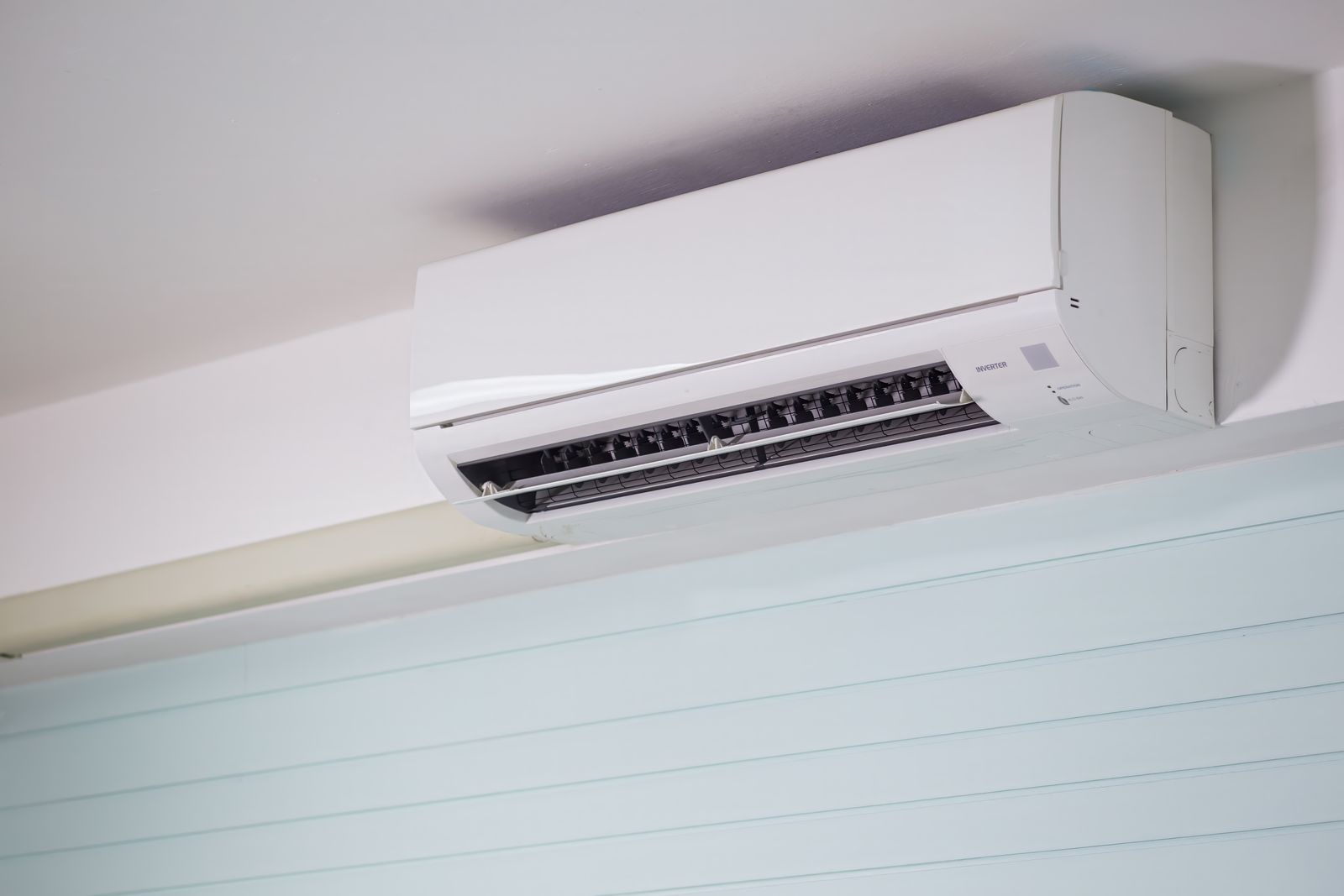 Imagem em close-up de um ar-condicionado de parede em ambiente interno, destacando o design elegante para soluções modernas de refrigeração.
